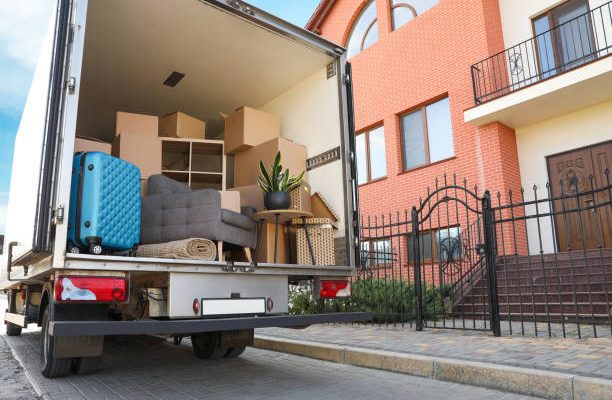 Van full of moving boxes and furniture near house