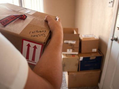 Close up shot of a man carrying a moving box
