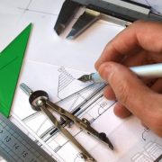 Architect working over blueprints, several drafting tools over the table