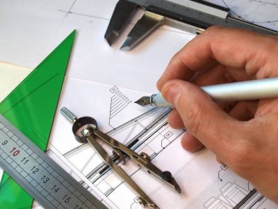 Architect working over blueprints, several drafting tools over the table