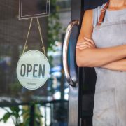 The woman is a waitress in an apron, the owner of the cafe stand