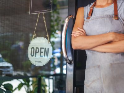 The woman is a waitress in an apron, the owner of the cafe stand