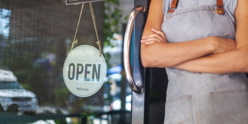 The woman is a waitress in an apron, the owner of the cafe stand