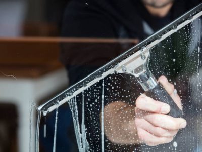 A soapy window with a squeegee cleaning the glass