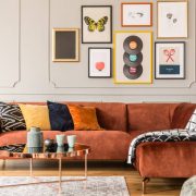 Eclectic living room interior with comfortable velvet corner sofa with pillows