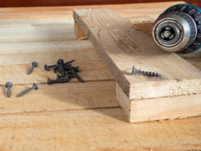 Self-tapping screws and a drill-screwdriver on wooden boards. home life, diy