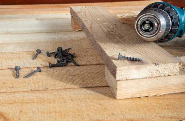 Self-tapping screws and a drill-screwdriver on wooden boards. home life, diy