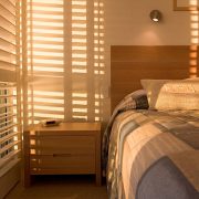 Beautiful golden light filtering through shutters in bedroom.