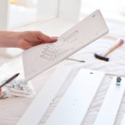 Woman looking at instruction manual to assemble new furniture