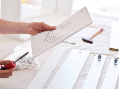 Woman looking at instruction manual to assemble new furniture