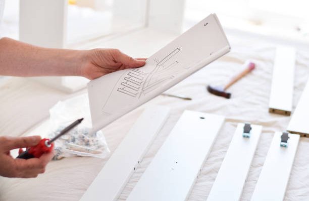 Woman looking at instruction manual to assemble new furniture
