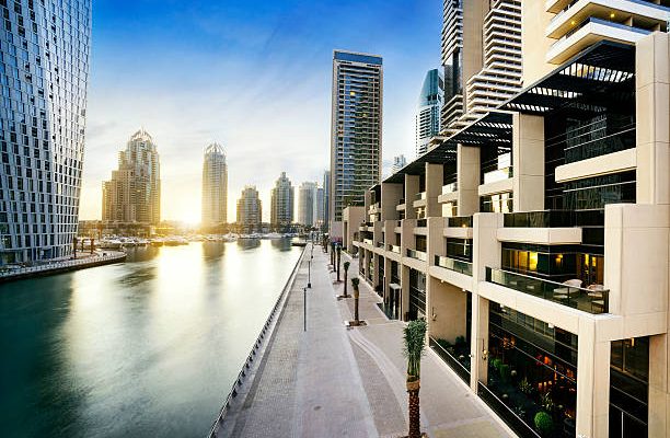 Skyline of dubai marina at night with boats, united arab emirates, middle east