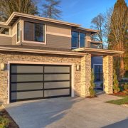 Modern contemporary house exterior with luxury details, landscaping, stone, wood, glass, lots of large windows.