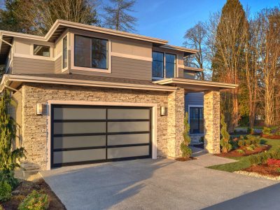 Modern contemporary house exterior with luxury details, landscaping, stone, wood, glass, lots of large windows.