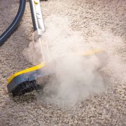 Using dry steam cleaner to sanitize floor carpet.