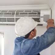 Air conditioner, ac repair and building hvac maintenance of a handyman and builder on home renovation. electric technician, service worker and contractor in a house for equipment installation on wall