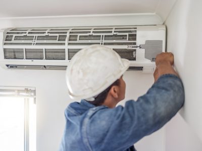 Air conditioner, ac repair and building hvac maintenance of a handyman and builder on home renovation. electric technician, service worker and contractor in a house for equipment installation on wall