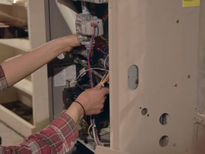 An hvac technician working on a furnace unit system