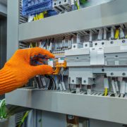 Hand of man electrical engineer mounts power energy shields close up photo