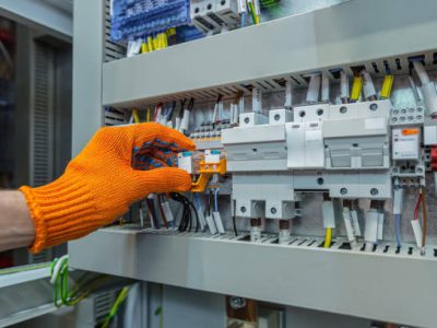 Hand of man electrical engineer mounts power energy shields close up photo