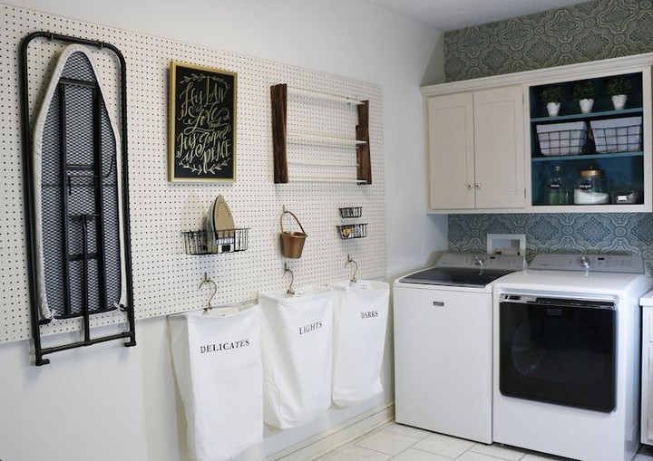 Look at how neat and complete this laundry room is. It has a complete facility where there is even an ironing board and storage to put the iron.