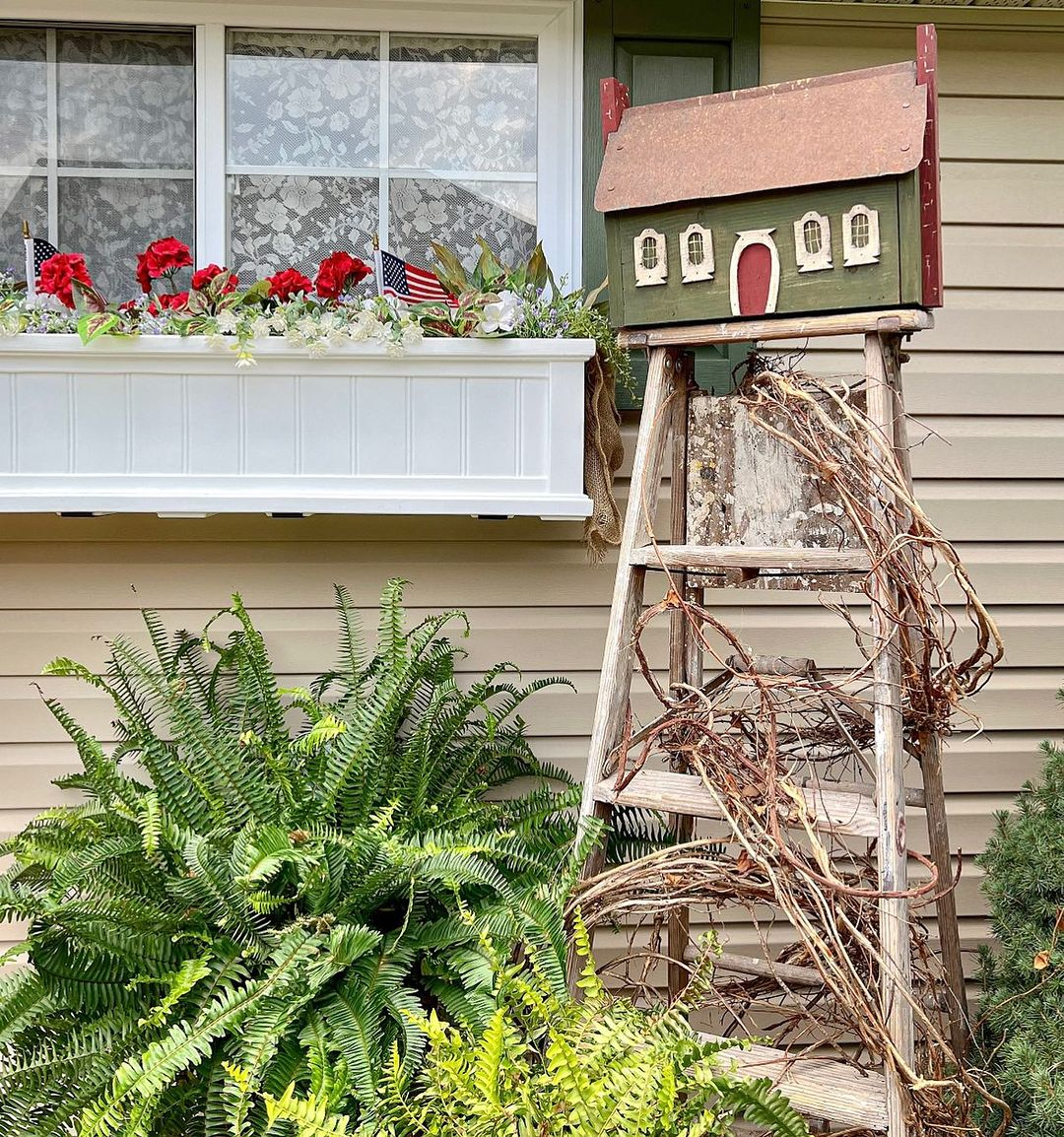 The birdhouse is placed on the top of the old ladder. It means that the ladder is used as the holder.