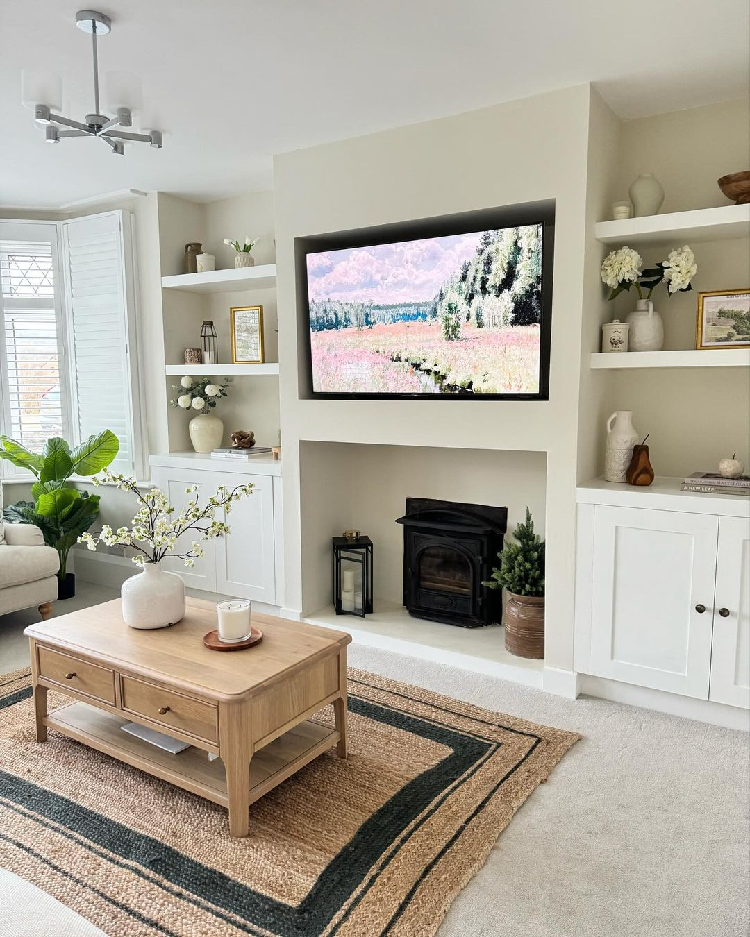 The shelving is built beside the television which is indented behind on the wall part. 