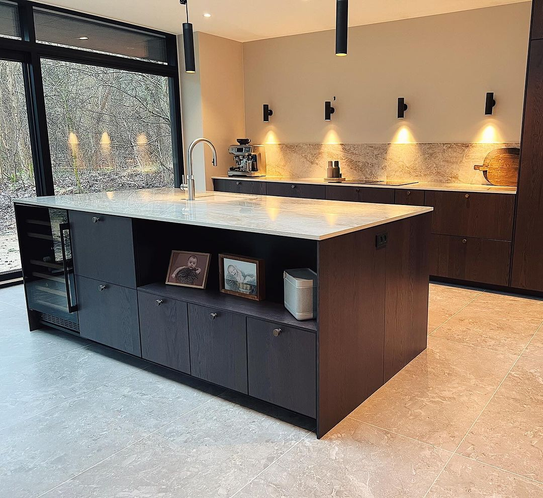 The granite material is used for many parts of this room. You can see it applied to the floor, backsplash, countertop, and kitchen island table.