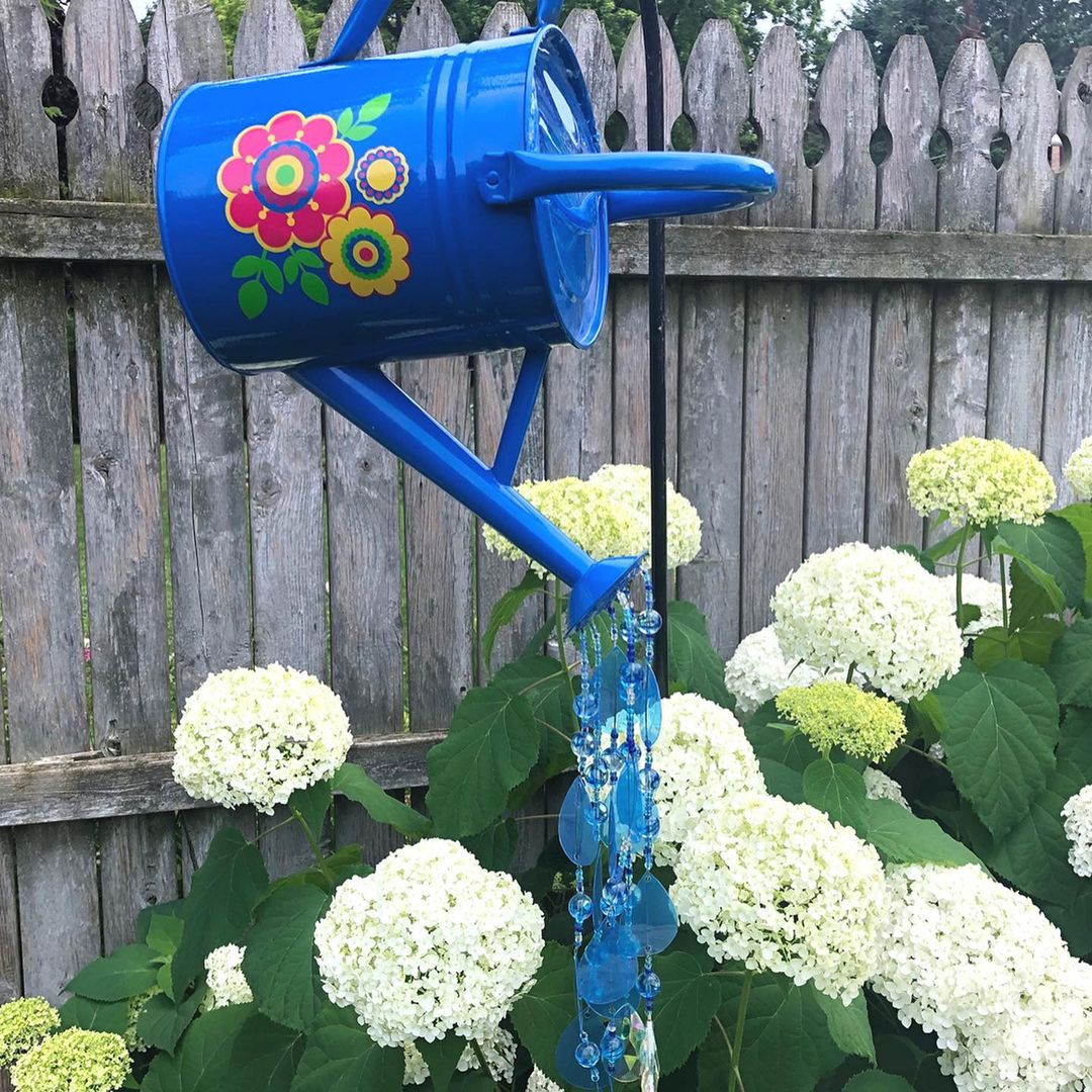 If you have an old watering can, you can use it to beautify the garden.
