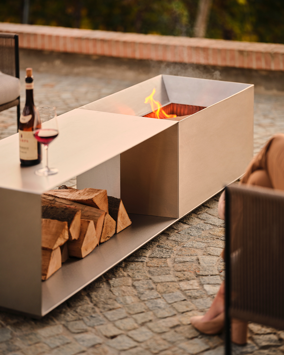 The firepit set design is simple, futuristic, yet functional. It has a furnace, wood storage, and a table space at once.
