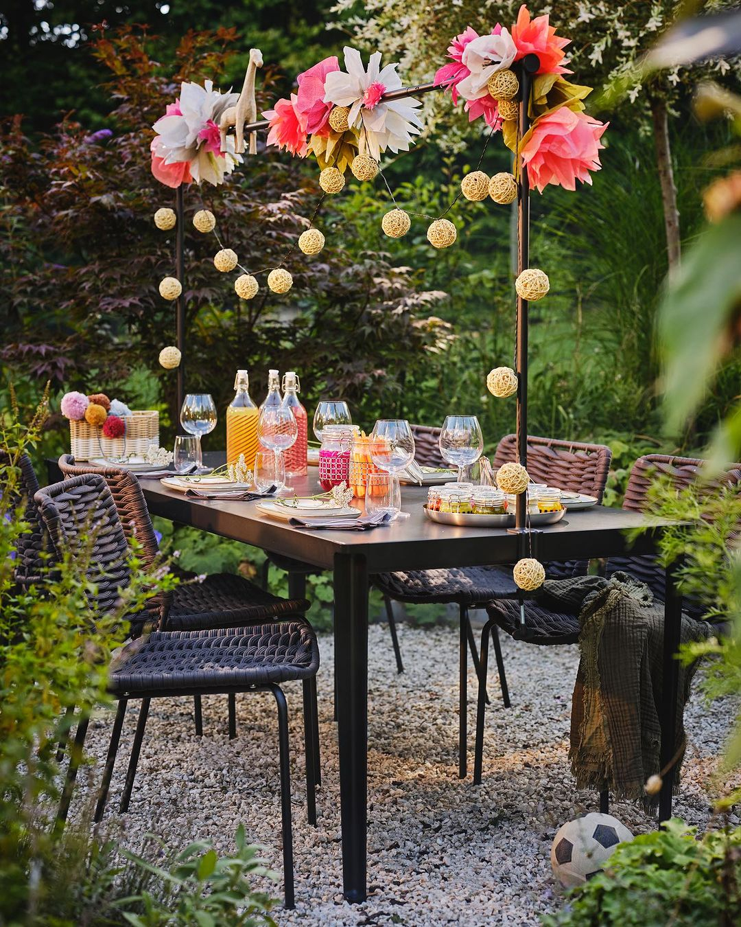 Look at how pretty this al fresco dining set is. It has a floral decoration with rattan ball lighting.