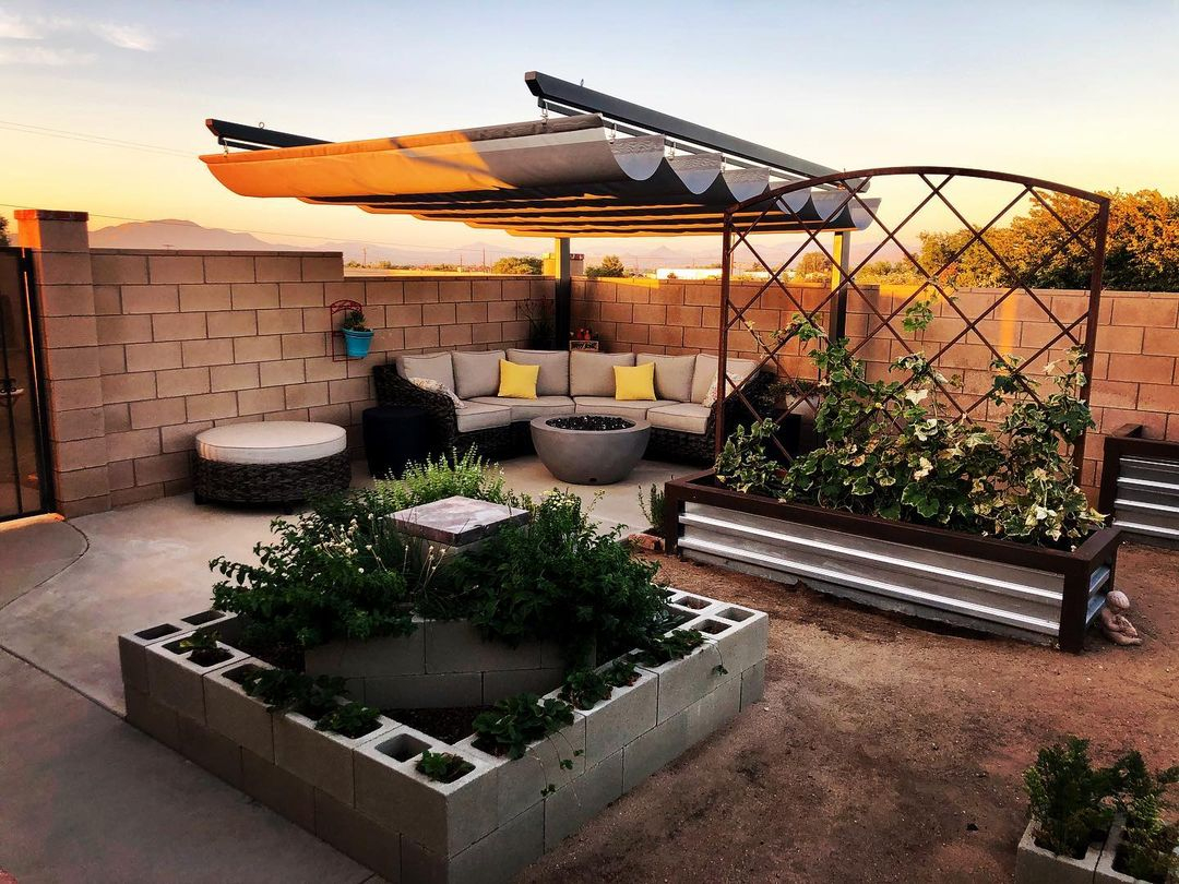 There is a retractable awning installed for this patio lounger. The location is in the corner with a firepit for comfort.