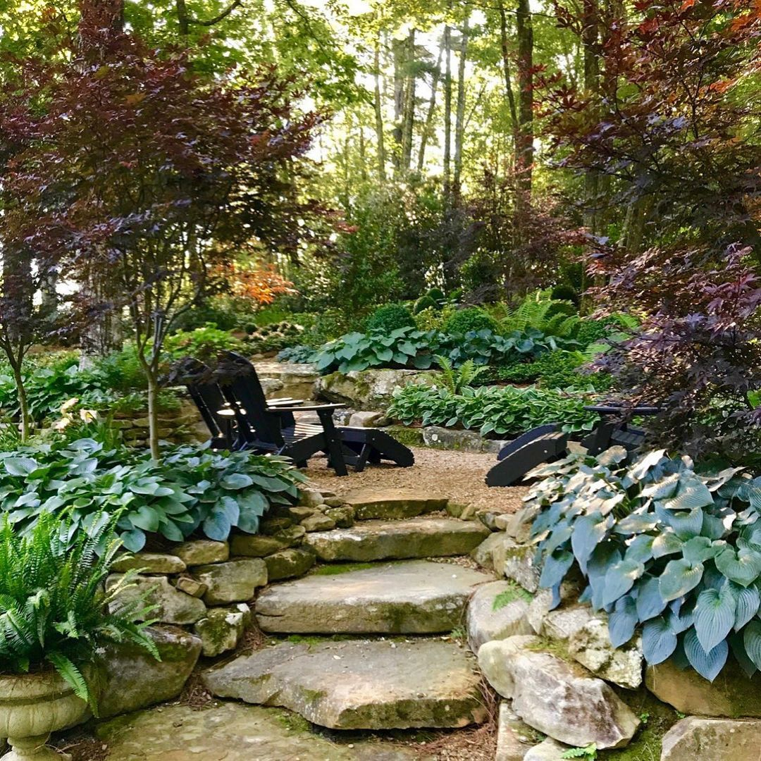 Use stone to create inviting paths. Then, you can add a cozy seating area in a shaded spot.