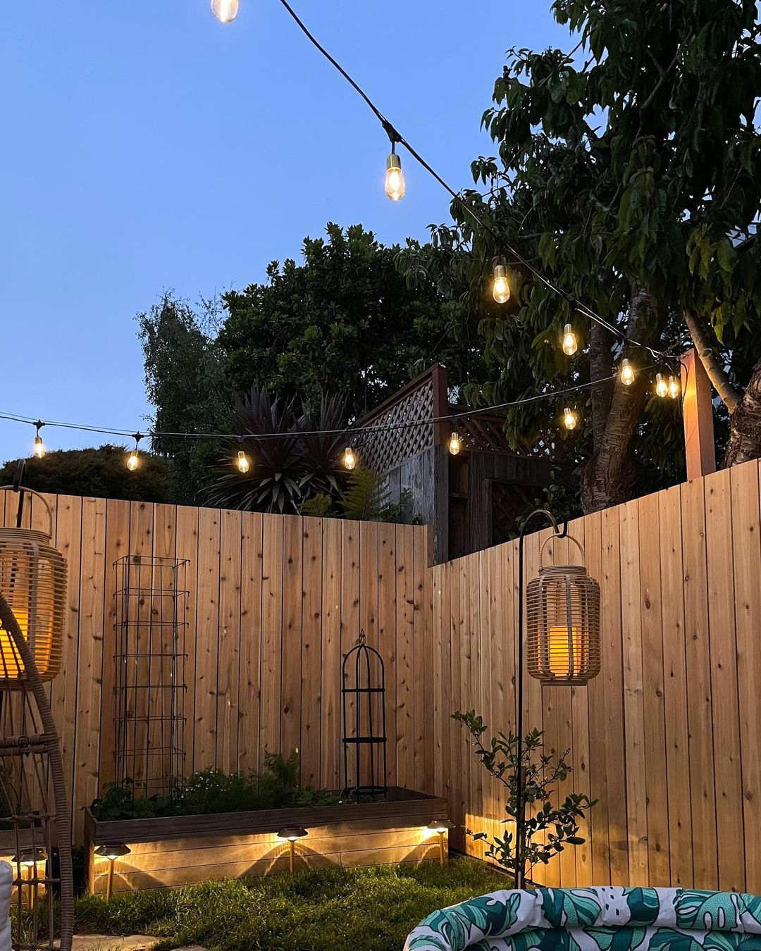 This patio area uses three different kinds of adorable lighting.