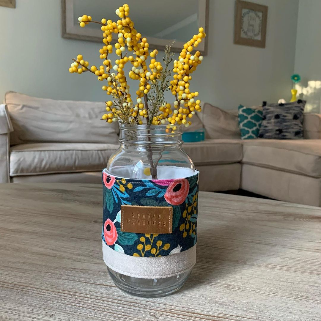 The mason jar is wrapped with the floral pattern fabric. It is great because the pattern is really harmonious with the spring theme.