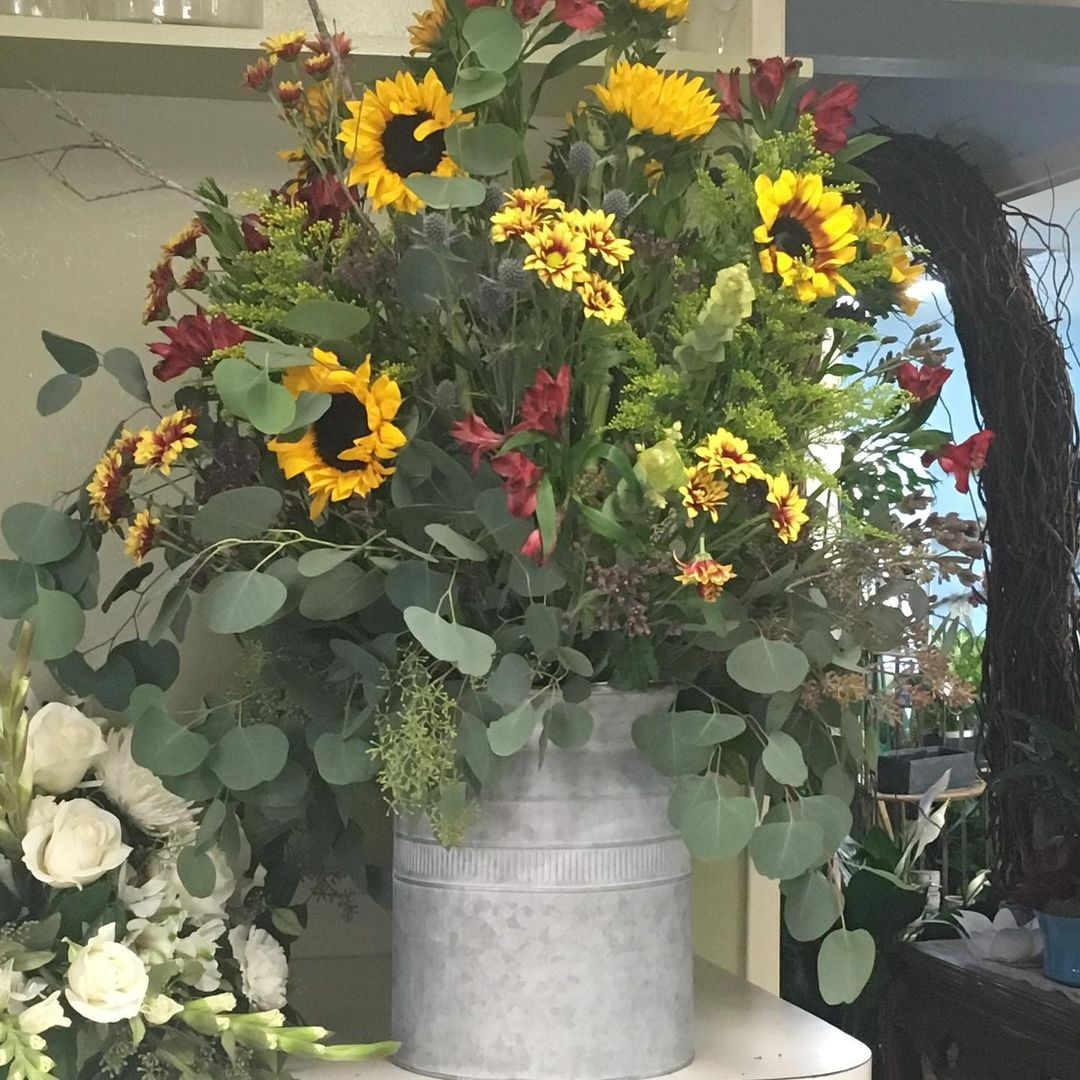 The first rustic thing that this flower arrangement has is the pot which is in the metal can.