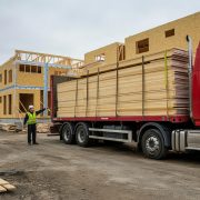 Man directs truck delivering siding